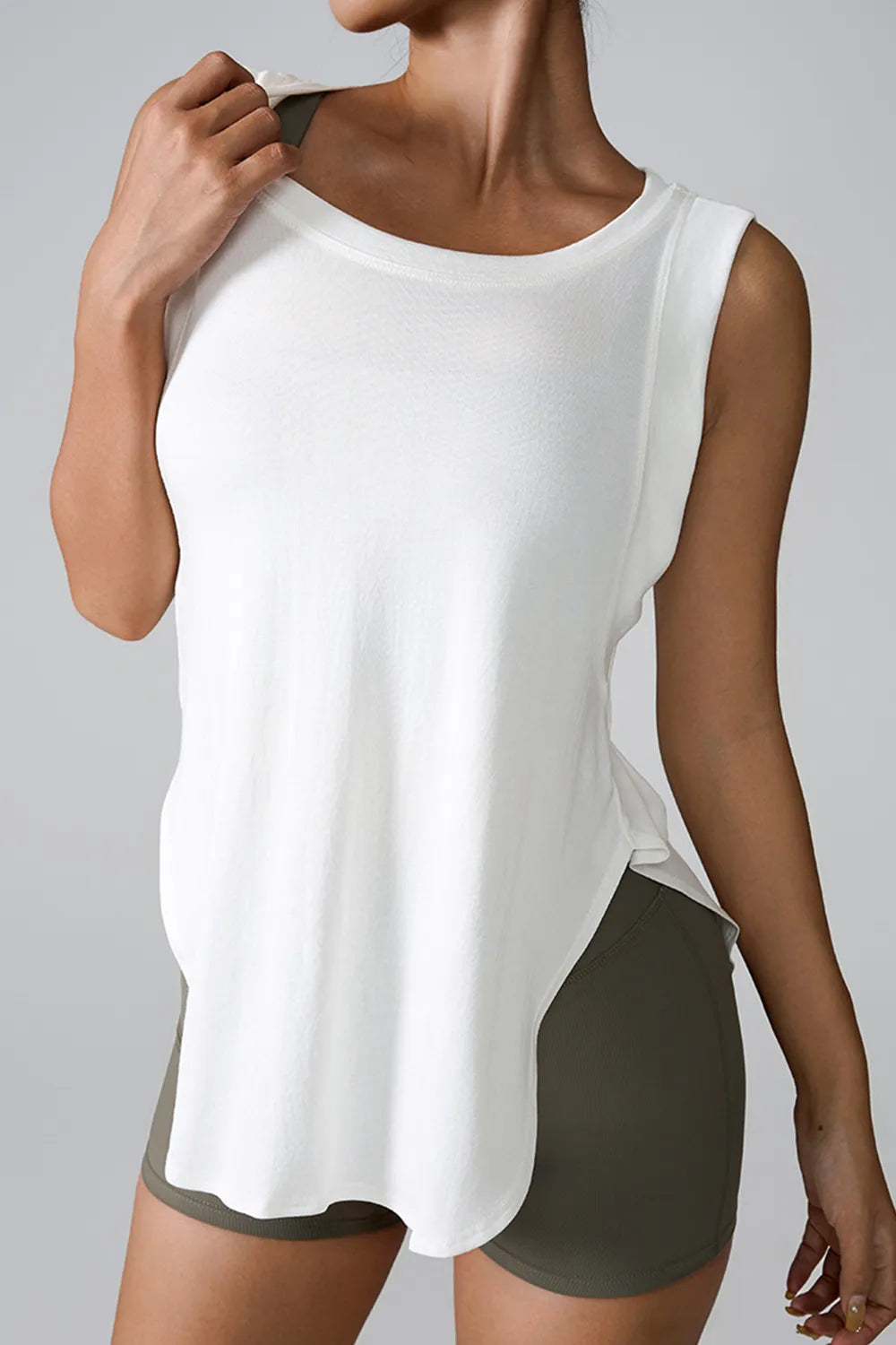 "Breathable white tank top with side slit for yoga and workout comfort"
