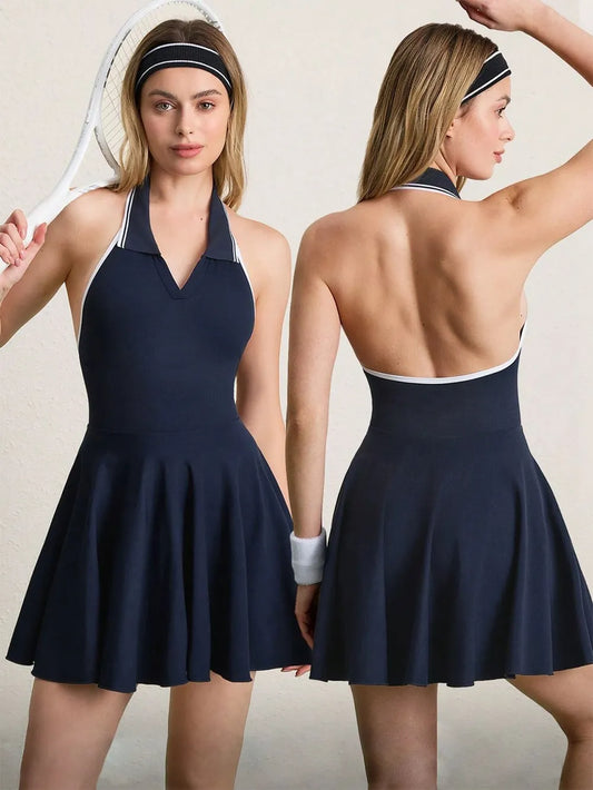 "Navy blue tennis dress with halter neckline, white trim details, and matching headband, shown from front and back views with tennis racket accessory."
