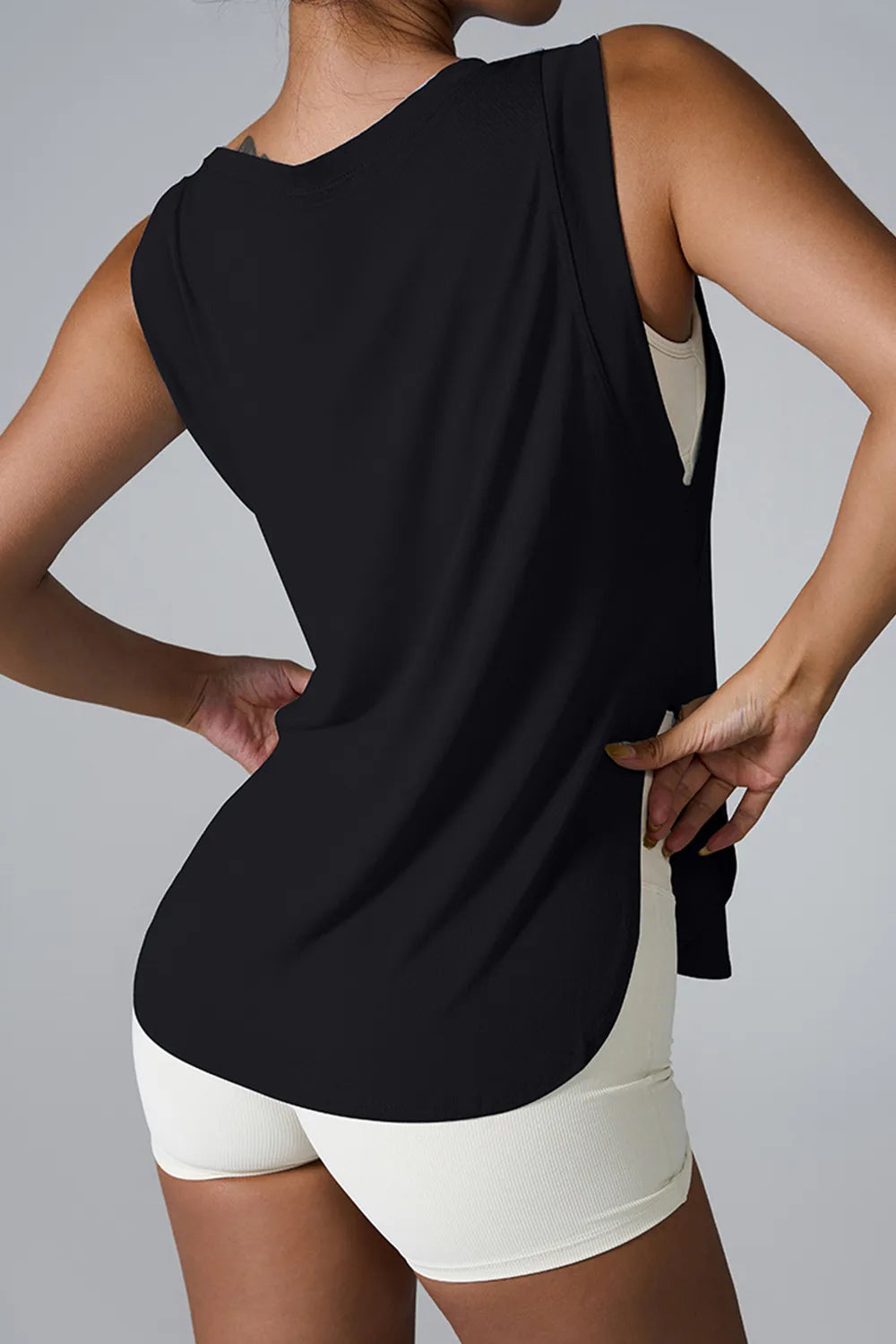 "Relaxed fit white sleeveless top paired with high-waisted olive leggings"
