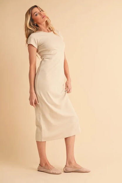 Woman wearing beige short sleeve maxi dress standing against a neutral background
-Max-Origin