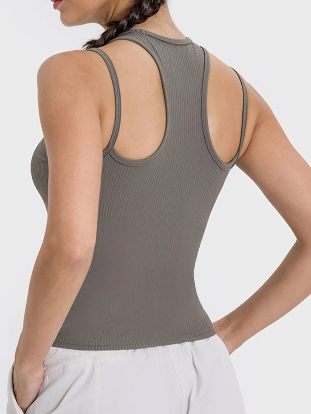 "Fitted gray-taupe athletic tank featuring a unique double-strap design, ribbed texture, and classic crew neck."
