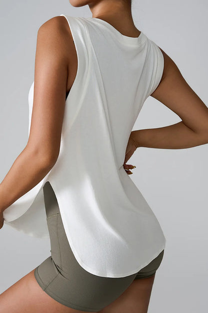 "Woman wearing loose white sleeveless top with scoop neckline and side detail"
