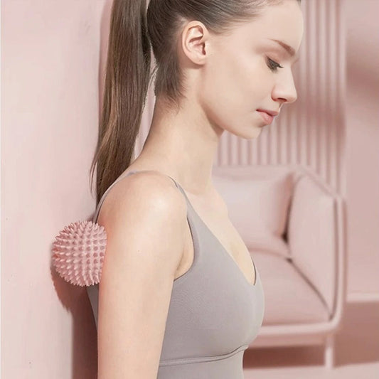 "Pink spiky massage ball shown next to woman's shoulder for myofascial release"
