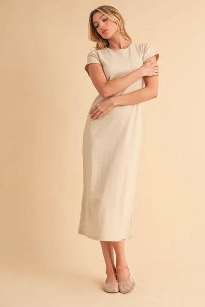 Woman wearing beige short sleeve maxi dress standing against a neutral background
Max-Origin