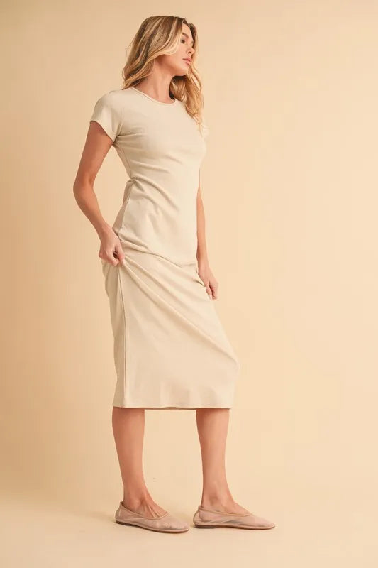 Woman wearing beige short sleeve maxi dress standing against a neutral background
-Max-Origin