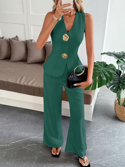 Woman wearing a green jumpsuit with gold buttons in an indoor setting.