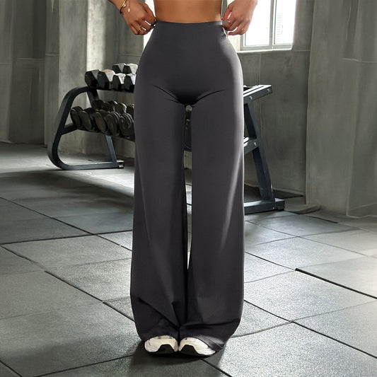 Women's dark gray high waist wide leg flowy yoga pants in gym setting